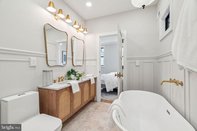 826 Tasker St, Philadelphia, PA 19148 - ensuite bathroom featuring a freestanding bath, wainscoting, double vanity, and a decorative wall