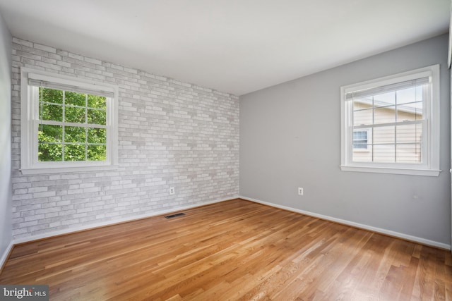 8818 Olympia Fields Ln, Vienna, VA 22182 - spare room with brick wall, baseboards, and wood finished floors