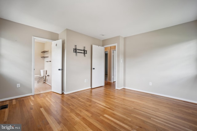 8818 Olympia Fields Ln, Vienna, VA 22182 - unfurnished bedroom featuring light wood-style flooring, baseboards, and ensuite bath