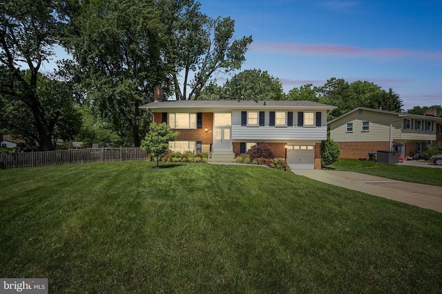 8818 Olympia Fields Ln, Vienna, VA 22182 - bi-level home featuring concrete driveway, a chimney, an attached garage, and brick siding