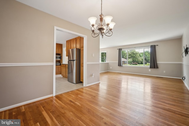 8818 Olympia Fields Ln, Vienna, VA 22182 - spare room with light wood-style floors, a chandelier, and baseboards