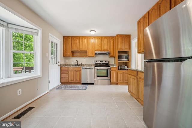 8818 Olympia Fields Ln, Vienna, VA 22182 - kitchen featuring stainless steel appliances, under cabinet range hood, a sink, and light stone counters