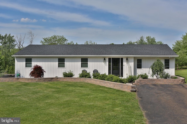 view of front of house with a front yard and a shingled roof