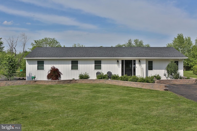 view of front of property with a front yard and roof with shingles