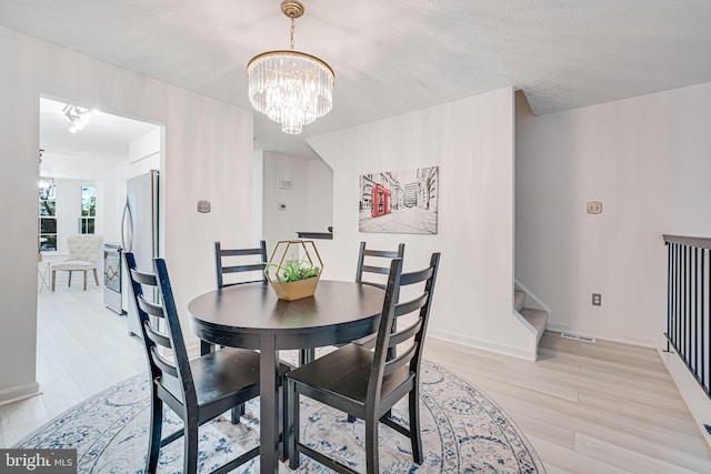 13916 Preacher Chapman Pl, Centreville, VA 20121 - dining room with stairs, light wood-style floors, and a chandelier