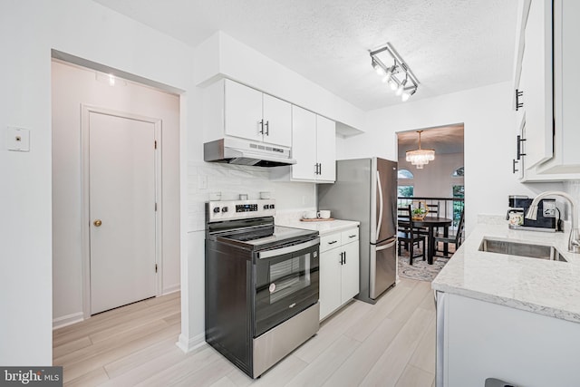 13916 Preacher Chapman Pl, Centreville, VA 20121 - kitchen with under cabinet range hood, appliances with stainless steel finishes, a sink, light wood-style floors, and a textured ceiling