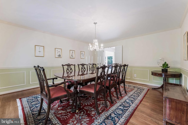 6808 Canal Bridge Ct, Potomac, MD 20854 - dining area with a chandelier, crown molding, wood finished floors, a decorative wall, and a wainscoted wall