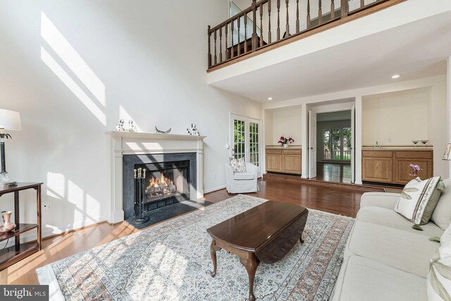 6808 Canal Bridge Ct, Potomac, MD 20854 - living area with wood finished floors, a fireplace with flush hearth, a towering ceiling, recessed lighting, and baseboards