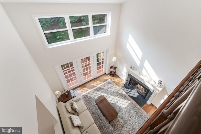 6808 Canal Bridge Ct, Potomac, MD 20854 - living room featuring a high ceiling, french doors, a fireplace with flush hearth, and wood finished floors