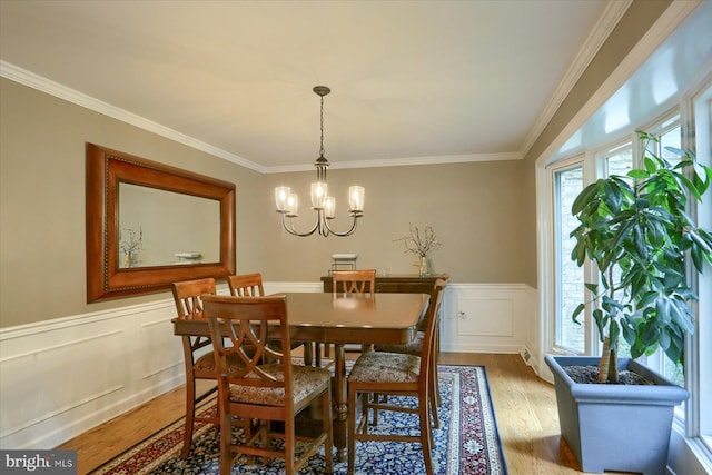 1715 Mountain View Rd, Harrisburg, PA 17110 - dining space with light wood-style floors, crown molding, a chandelier, wainscoting, and a decorative wall