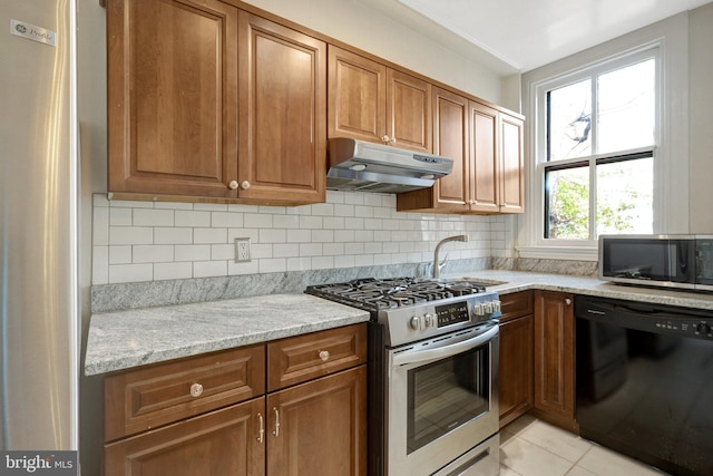 812 E St SE, Washington, DC 20003 - kitchen featuring stainless steel appliances, under cabinet range hood, a sink, and brown cabinets