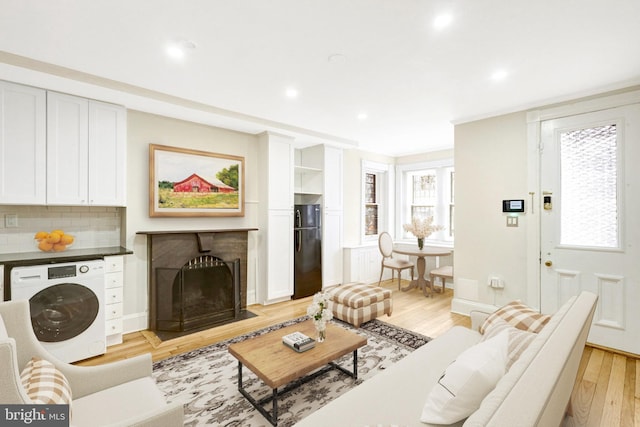 812 E St SE, Washington, DC 20003 - living room featuring washer / clothes dryer, light wood-type flooring, a fireplace with flush hearth, recessed lighting, and baseboards