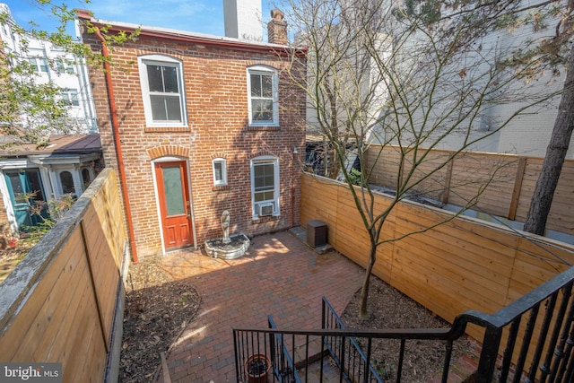 812 E St SE, Washington, DC 20003 - back of property with brick siding, a chimney, a fenced backyard, cooling unit, and a patio
