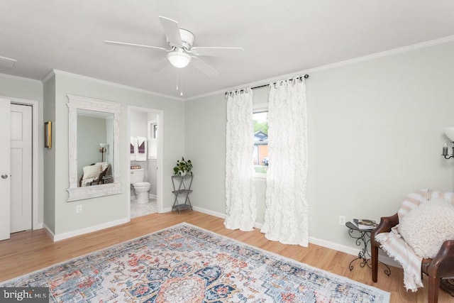 living area with wood finished floors, ornamental molding, baseboards, and ceiling fan