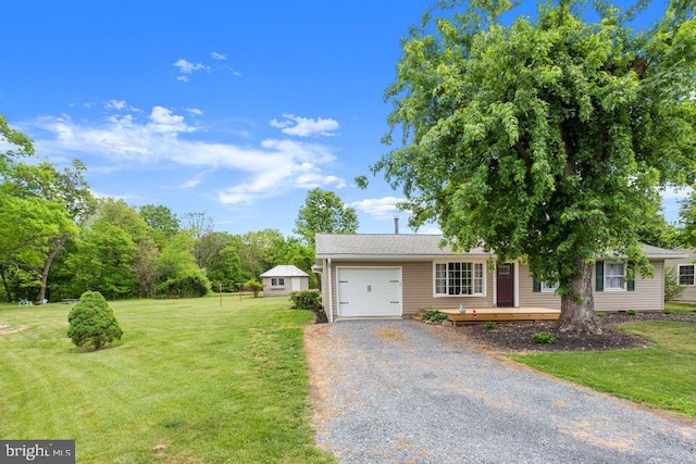 view of front of property with a garage, gravel driveway, and a front lawn