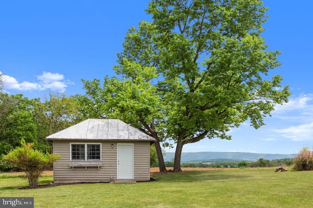 view of green lawn with an outbuilding