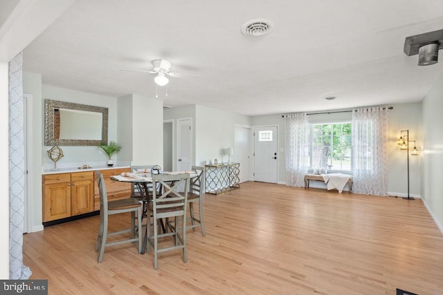 dining room featuring light wood-style floors, baseboards, and ceiling fan