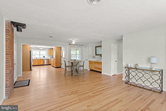 living area featuring light wood-style floors and baseboards