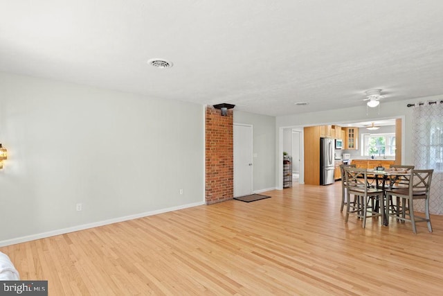 dining space featuring light wood-style floors, baseboards, and ceiling fan