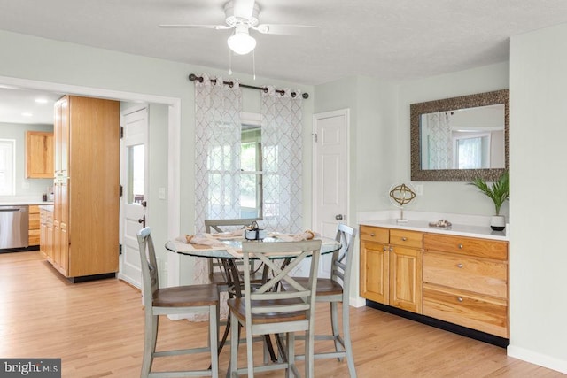dining area featuring light wood-style flooring and a ceiling fan
