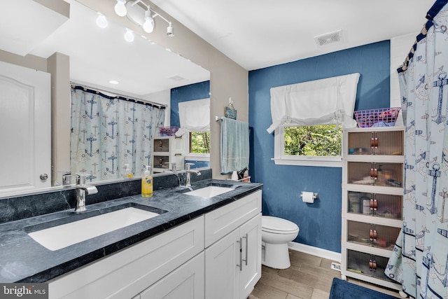 463 Bronco Trl, Lusby, MD 20657 - full bathroom with toilet, wood finished floors, double vanity, baseboards, and a shower with shower curtain