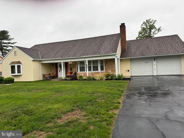60 Windsor Ln, Willingboro, NJ 08046 - view of front of property with an attached garage, asphalt driveway, a chimney, a front yard, and a porch