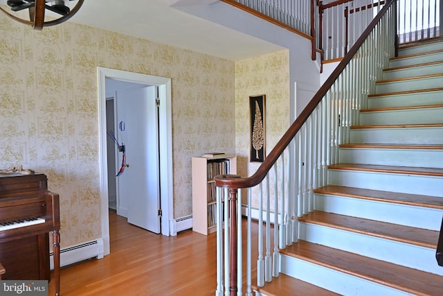 9706 Fairway Dr, New Market, VA 22844 - stairs featuring baseboard heating, wood finished floors, a baseboard radiator, wallpapered walls, and baseboards