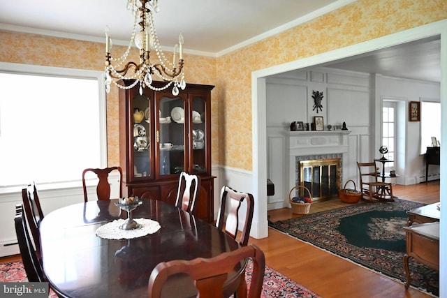 9706 Fairway Dr, New Market, VA 22844 - dining space with a chandelier, a baseboard radiator, wallpapered walls, wood finished floors, and ornamental molding