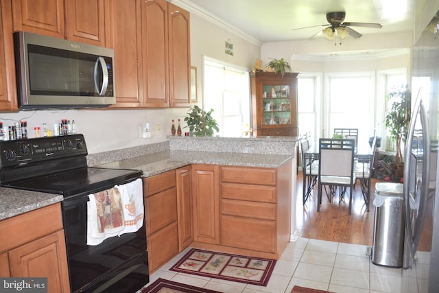 7226 Waldman Ave, Sparrows Point, MD 21219 - kitchen featuring appliances with stainless steel finishes, healthy amount of natural light, ceiling fan, light tile patterned flooring, and crown molding