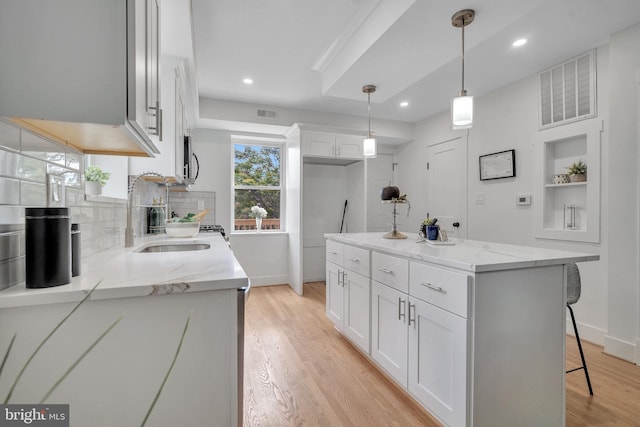 1636 40th St SE, Washington, DC 20020 - kitchen with baseboards, light wood finished floors, backsplash, white cabinetry, and recessed lighting