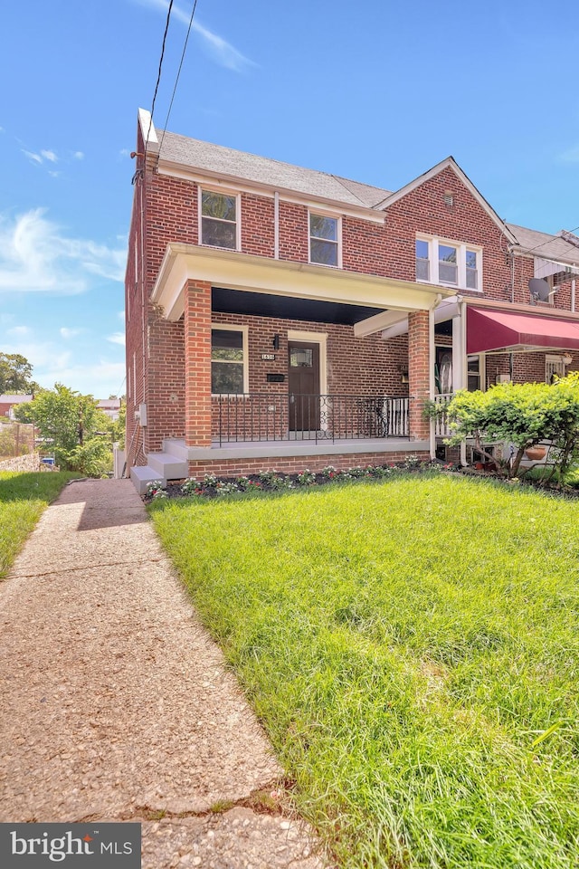 1636 40th St SE, Washington, DC 20020 - view of property with brick siding, a front yard, and covered porch