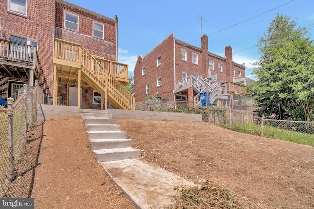 1636 40th St SE, Washington, DC 20020 - back of property with stairway, a fenced backyard, brick siding, and a wooden deck