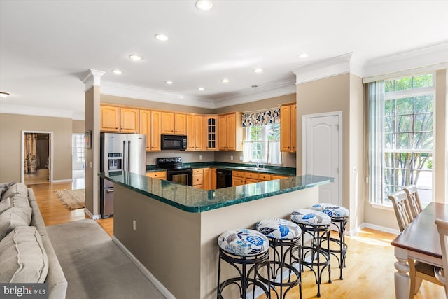 11625 Manklin Creek Rd, Ocean Pines, MD 21811 - kitchen with black appliances, ornamental molding, recessed lighting, light wood finished floors, and a kitchen bar