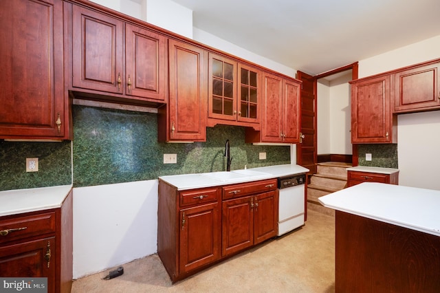 kitchen with dishwasher, a sink, light carpet, and light countertops