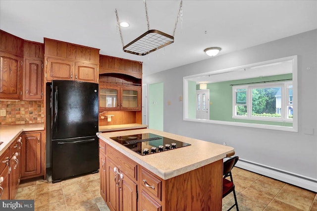 kitchen featuring black appliances, light countertops, baseboard heating, and brown cabinets