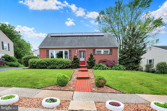 dutch colonial featuring brick siding, roof with shingles, and a front yard