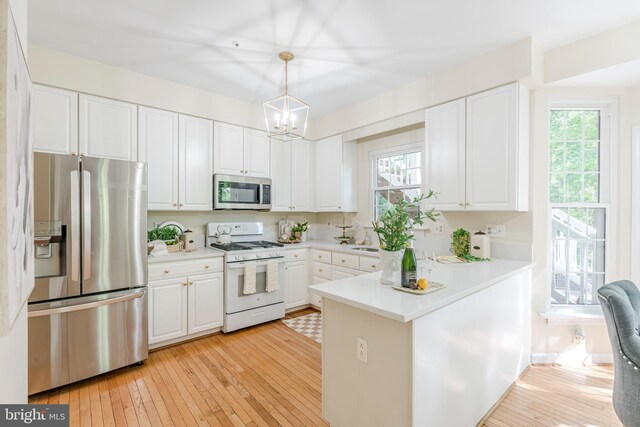 12221 Quadrille Ln, Bowie, MD 20720 - kitchen featuring stainless steel appliances, plenty of natural light, a peninsula, and white cabinets