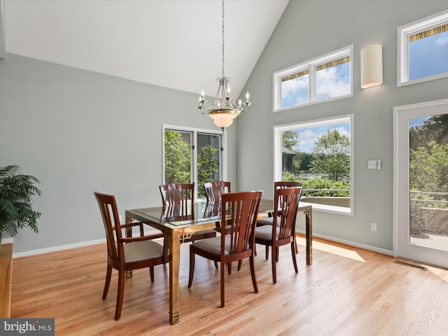 11583 Greenwich Point Rd, Reston, VA 20194 - dining area with a chandelier, high vaulted ceiling, light wood-style flooring, and baseboards