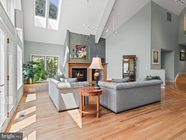 11583 Greenwich Point Rd, Reston, VA 20194 - living area with high vaulted ceiling, track lighting, a skylight, wood finished floors, and a tile fireplace