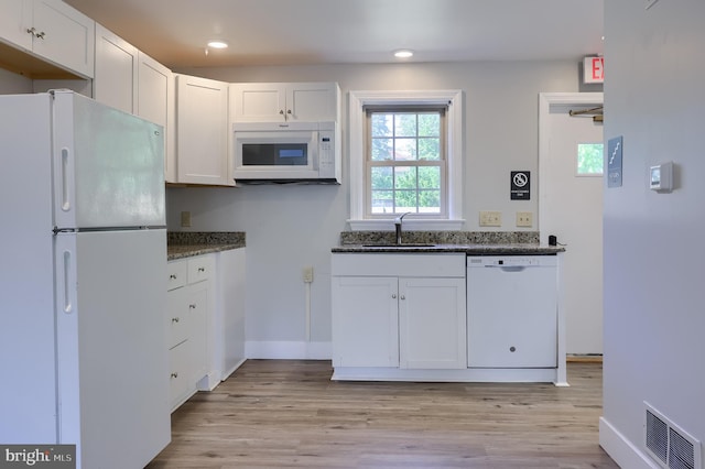 kitchen featuring white appliances, a sink, light wood finished floors, white cabinetry, and recessed lighting