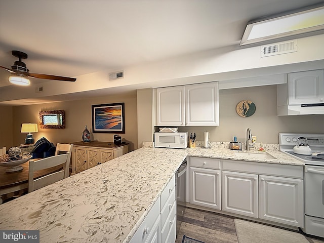 435 Lekites Ave Unit 435, Bethany Beach, DE 19930 - kitchen featuring white appliances, a sink, light stone countertops, white cabinetry, and wood finished floors