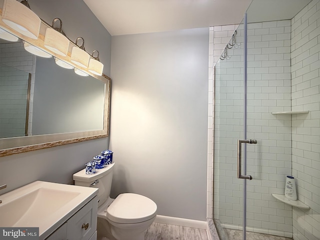 435 Lekites Ave Unit 435, Bethany Beach, DE 19930 - bathroom featuring a stall shower, wood finished floors, toilet, vanity, and baseboards