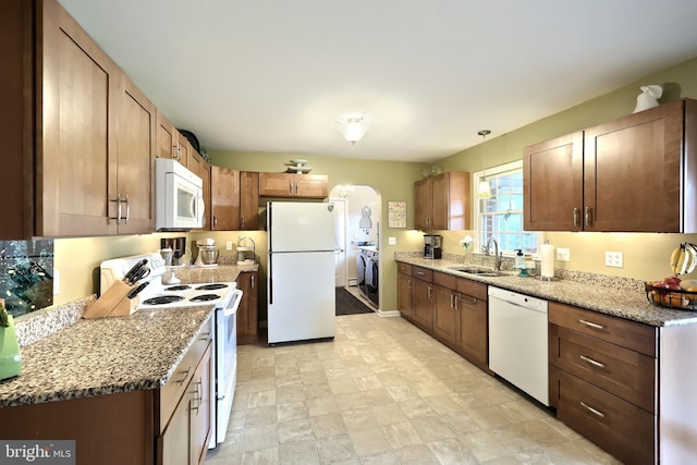 165 Wappler Dr, Hanover, PA 17331 - kitchen featuring white appliances, a sink, arched walkways, light stone counters, and hanging light fixtures