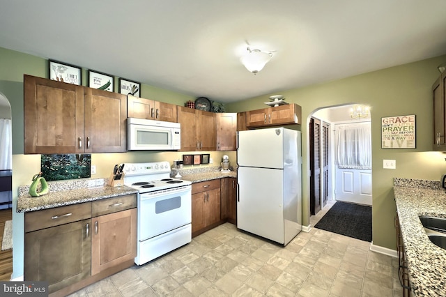 165 Wappler Dr, Hanover, PA 17331 - kitchen with white appliances, arched walkways, light stone countertops, and a chandelier