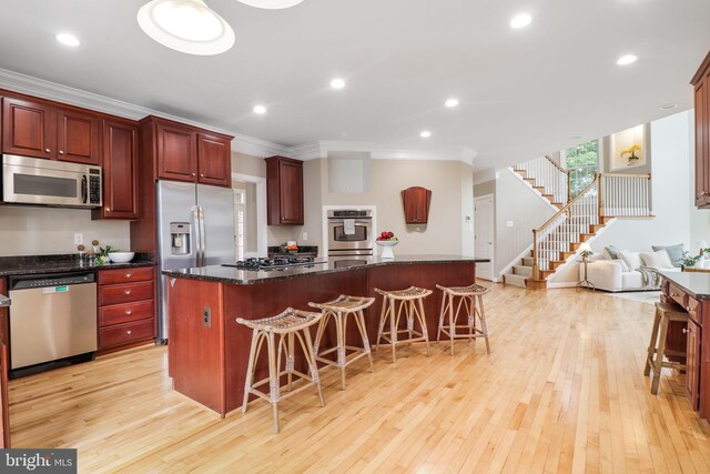710 Crisfield Way, Annapolis, MD 21401 - kitchen with stainless steel appliances, ornamental molding, light wood-type flooring, a center island, and a breakfast bar
