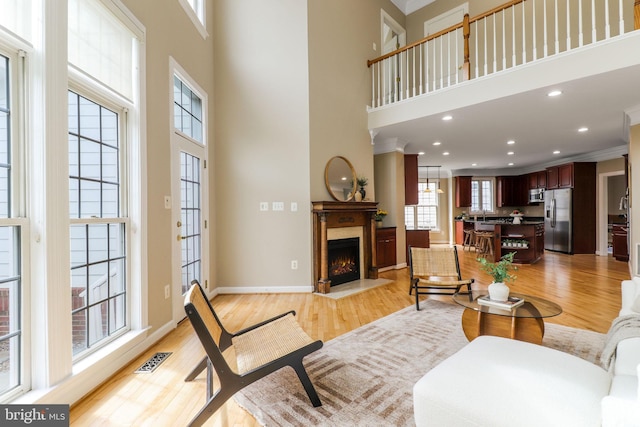 710 Crisfield Way, Annapolis, MD 21401 - living area with a towering ceiling, light wood-type flooring, a fireplace with flush hearth, baseboards, and recessed lighting