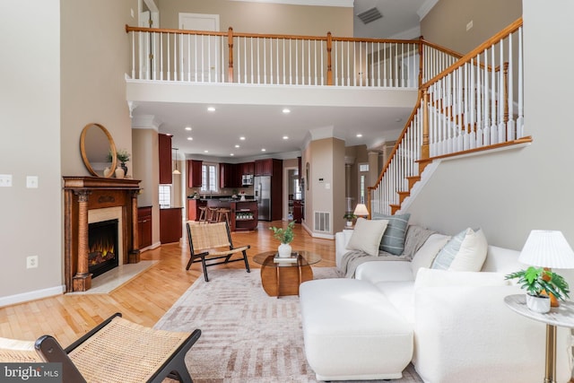 710 Crisfield Way, Annapolis, MD 21401 - living room with crown molding, light wood finished floors, stairs, a towering ceiling, and a high end fireplace