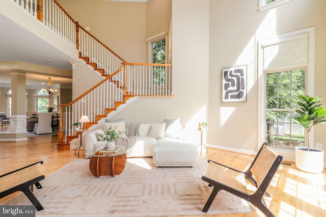 710 Crisfield Way, Annapolis, MD 21401 - living room featuring a high ceiling, wood finished floors, stairs, a chandelier, and decorative columns