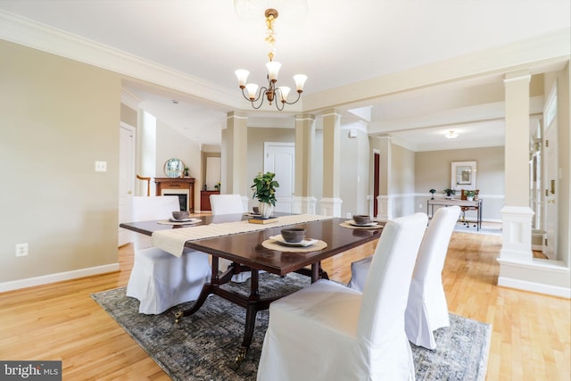 710 Crisfield Way, Annapolis, MD 21401 - dining space with decorative columns, light wood-type flooring, crown molding, a chandelier, and baseboards