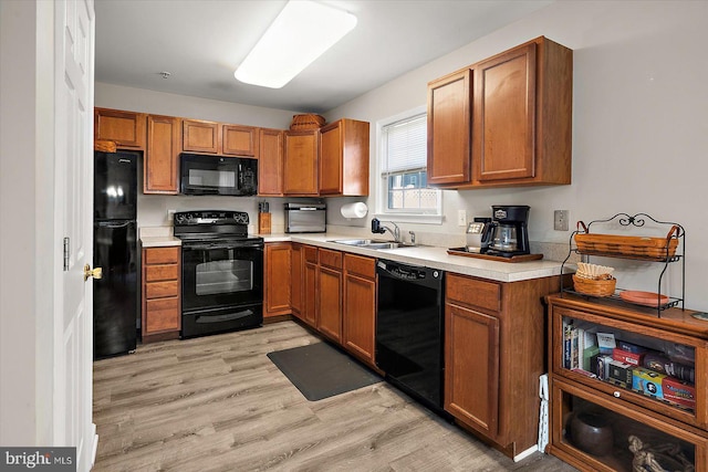 425 Lindenhurst Ct, Salisbury, MD 21804 - kitchen with black appliances, a sink, brown cabinets, light countertops, and light wood-style floors